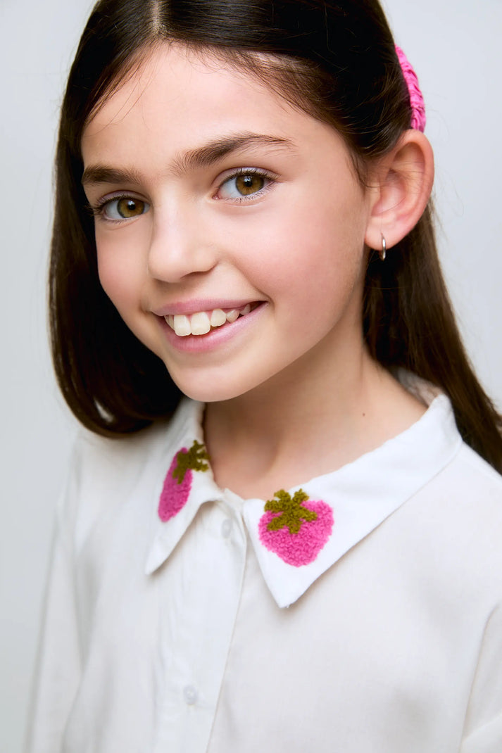 Camicia bianca da bambina con colletto ricamato a forma di fragola.